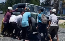 Người lớn, trẻ em hợp sức nâng ô tô điện cứu học sinh kẹt dưới gầm