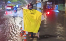 Người đàn ông ở TP.HCM bì bõm trong đêm hướng dẫn xe tránh đường ngập