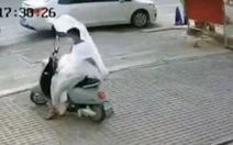 Chàng trai bối rối khi bị áo mưa bay trên đường quấn vào người