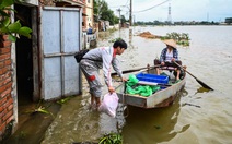 Hình ảnh dân đi thuyền trên tỉnh lộ ngập sâu ở ngoại thành Hà Nội