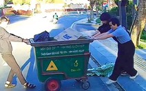 Ba thanh niên loay hoay mãi không kéo được xe rác lên vỉa hè