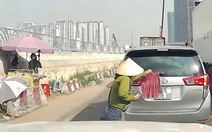 Cô bán vé số tốt bụng, giúp chủ ô tô gỡ chiếc khăn che lấp một phần biển số
