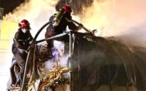 Xe tải chở gỗ bốc cháy, cảnh sát đeo mặt nạ chống độc để dập lửa