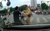 Thanh niên không đội mũ bảo hiểm chờ đèn đỏ bị cảnh sát giao thông tuýt còi