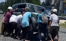 Người lớn, trẻ em hợp sức nâng ô tô điện cứu học sinh kẹt dưới gầm