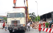 Dân giúp tài xế thu gom sữa sau khi xe lật nhào