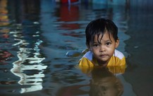 Người dân đắp ‘đê’ trước cửa nhà, trẻ em bơi giữa dòng triều cường đạt đỉnh tại TP.HCM