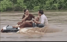 Hai vợ chồng 'chill' trên nóc xe giữa dòng nước lũ gây sốt mạng xã hội: 'Cứ như ngồi nhà hàng'