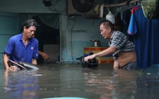 Dân TP Thủ Đức bì bõm thu dọn đồ đạc sau trận mưa ngập đến nửa nhà