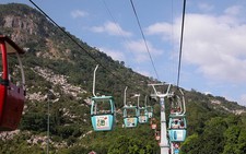 Ngồi cáp treo cầm mây trắng trong tay