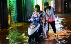 Người dân vẫn bì bõm trong dòng nước ngập dù mưa đã tạnh từ lâu
