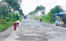 Đường Xuyên Á bể nát, dân vất vả lấp ổ gà cho xe đi lại