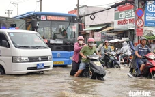 Đường Văn Tiến Dũng ‘chìm’ trong triều cường, người dân chung tay căng bạt, đắp cát ngăn nước