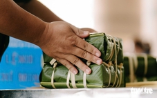 Đĩa bánh chưng, túi cam treo trước cửa trong ngõ nhỏ của người hàng xóm không quen