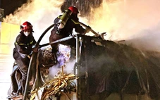 Xe tải chở gỗ bốc cháy, cảnh sát đeo mặt nạ chống độc để dập lửa