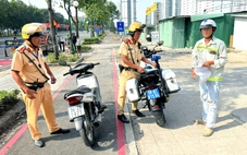 Cảnh sát giao thông xử phạt người chạy xe máy vào làn dành riêng cho xe đạp trên đường Mai Chí Thọ