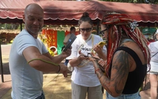 Du khách dạn tay ôm rắn chụp hình tại Trại rắn Đồng Tâm