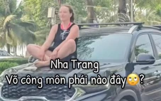 Nữ du khách ngồi 'hóng gió' trên nắp ca pô xe hơi chạy trên đường ở Nha Trang