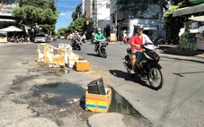 Nhiều người sụp 'ổ voi' trước chợ, dân dựng thùng xốp cảnh báo