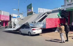 Vừa mua xong điện thoại, người phụ nữ bị bảng hiệu tiệm điện thoại sập đè trúng