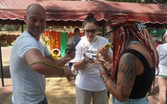 Du khách dạn tay ôm rắn chụp hình tại Trại rắn Đồng Tâm