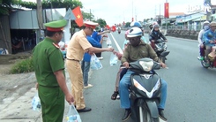 Người dân miền Tây về quê nghỉ lễ được cảnh sát giao thông phát nước uống, khăn lạnh