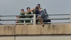 Khoảnh khắc cảnh sát lao vào giải cứu thanh niên đứng ngoài lan can cầu vượt đường sắt