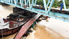 Cụm sà lan bị lũ cuốn trôi mắc kẹt ở trụ cầu Mỹ Chánh trên tuyến đường sắt Bắc Nam
