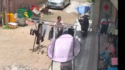 Cô gái ôm sào phơi đồ đi ra đi vào mỏi chân vì trời nắng mưa thất thường