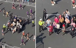 Nhân viên giải marathon căng dây dẫn khán giả qua đường đua