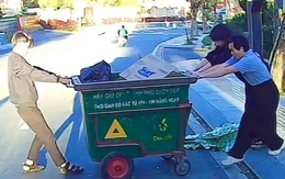 Ba thanh niên loay hoay mãi không kéo được xe rác lên vỉa hè