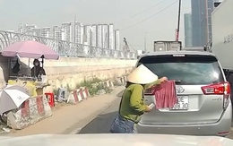 Cô bán vé số tốt bụng, giúp chủ ô tô gỡ chiếc khăn che lấp một phần biển số