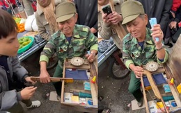 Cụ ông không cho chàng trai đặt súng khi chơi trò bắn vịt nhựa du xuân