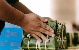 Đĩa bánh chưng, túi cam treo trước cửa trong ngõ nhỏ của người hàng xóm không quen