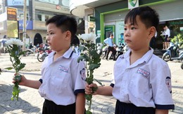 Người dân cầm hoa trắng đợi tiễn đưa các anh