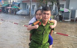 Giữa dòng nước ngập, xe ô tô chạy chậm lại, người lạ xúm nhau đỡ người và xe bị ngã