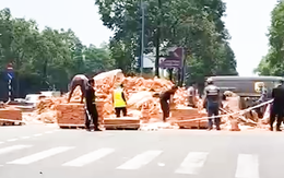 Xe container vào cua làm rơi hàng tấn gạch xuống đường ở TP.HCM