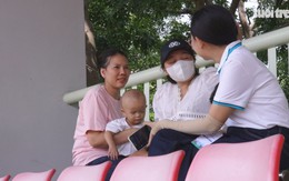 Ẵm con 18 tháng tuổi theo cổ vũ chồng thi đấu giải bóng đá công nhân