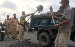 ​CSGT mướt mồ hôi hốt đá dăm rơi trên đường