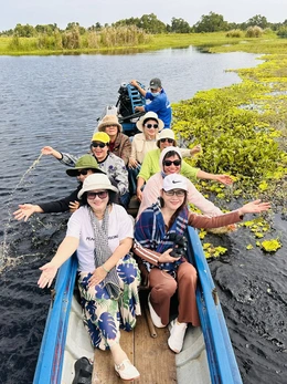 Du khách ngồi vỏ lãi, đội khăn rằn trải nghiệm ngắm cảnh Vườn quốc gia U Minh Thượng