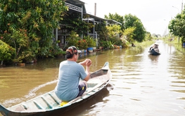 Coastal residents in southernmost Vietnam paddle boats on flooded roads despite not being in flood zone