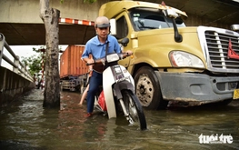 Ho Chi Minh City residents wade through flooded streets at rush hour as high tide hits again