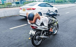 Người đàn ông 39 tuổi thả 2 tay, nằm ngửa trên xe máy chạy qua cầu Rồng