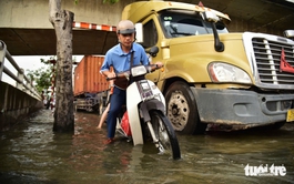 Ho Chi Minh City residents wade through flooded streets at rush hour as high tide hits again