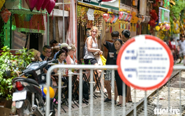 Foreign tourists persist at Hanoi trackside café street after woman purposely approaches oncoming train