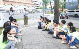 No classroom. These students practice English with foreign visitors in a city park.