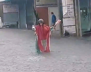 Ông Đắc Lắc chuyên đội mưa chỉ đường cho xe máy, ô tô tránh ngập ở TP.HCM
