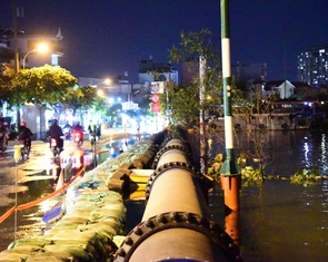 Đắp bao cát ngăn nước kênh Tẻ tràn vào đường Trần Xuân Soạn khi triều cường
