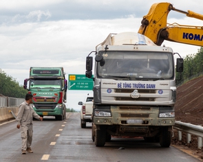 Xe đầu kéo, ô tô chạy nườm nượp trên cao tốc chưa khai thác, công nhân vừa làm vừa run