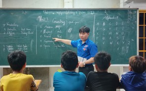 Chàng sinh viên đứng bục giảng với màu áo xanh tình nguyện
